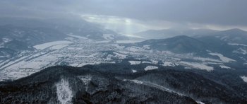 Movie still from “Broken” (2021), directed by Patrick Phillips – A view of a valley with snow on the ground and trees; Extreme Wide shot, High angle