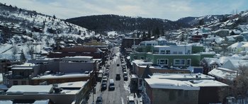 Movie still from “Broken” (2021), directed by Patrick Phillips – An aerial view of a street with cars driving down it; Extreme Wide shot, High angle