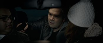 Movie still from “Broken” (2021), directed by Patrick Phillips – A man sitting in the back seat of a car; Close Up shot, Over the shoulder angle