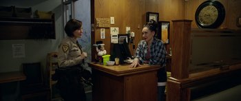 Movie still from “Broken” (2021), directed by Patrick Phillips – Two women standing at a counter talking to each other; Medium shot, Over the shoulder angle