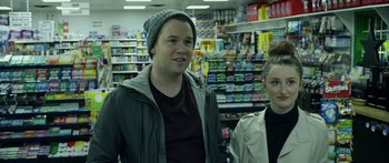 Movie still from “Broken” (2021), directed by Patrick Phillips – A man and a woman standing in front of a store; Close Up shot, Over the shoulder angle
