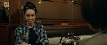 Movie still from “Broken” (2021), directed by Patrick Phillips – A woman sitting at a table in front of a coffee pot; Close Up shot, Over the shoulder angle
