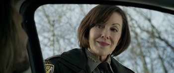 Movie still from “Broken” (2021), directed by Patrick Phillips – A person wearing a uniform; Close Up shot, Over the shoulder angle