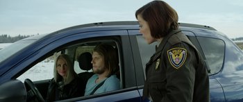 Movie still from “Broken” (2021), directed by Patrick Phillips – A man sitting in the driver's seat of a blue car; Medium shot, Over the shoulder angle