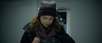 Movie still from “Broken” (2021), directed by Patrick Phillips – A person wearing a hat and holding a purse; Close Up shot, Over the shoulder angle