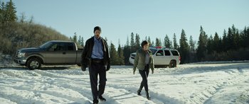 Movie still from “Broken” (2021), directed by Patrick Phillips – A man and a woman are walking in the snow; Wide shot, Low angle
