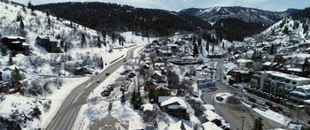 Movie still from “Broken” (2021), directed by Patrick Phillips – An aerial view of a town with a lot of snow on the ground; Extreme Wide shot, High angle