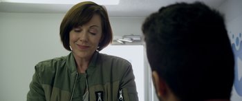 Movie still from “Broken” (2021), directed by Patrick Phillips – A woman in a green jacket talking to a man in a green jacket; Close Up shot, Over the shoulder angle