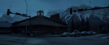 Movie still from “Broken” (2021), directed by Patrick Phillips – A street scene with a clock tower in the background; Extreme Wide shot, Low angle