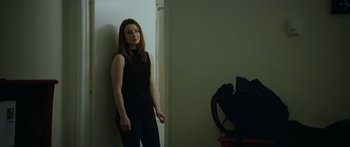 Movie still from “Broken” (2021), directed by Patrick Phillips – A woman leaning against a wall in front of a fan; Medium shot, Over the shoulder angle