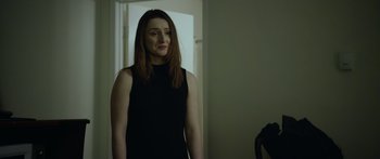 Movie still from “Broken” (2021), directed by Patrick Phillips – A woman in a black dress standing in front of a mirror; Medium shot, Over the shoulder angle