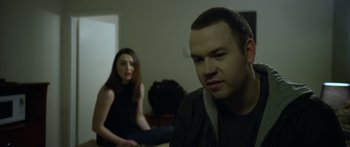 Movie still from “Broken” (2021), directed by Patrick Phillips – A man and a woman sitting in a living room; Close Up shot, Over the shoulder angle