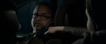 Movie still from “Broken” (2021), directed by Patrick Phillips – A man sitting in the back seat of a car holding a microphone; Close Up shot, Over the shoulder angle