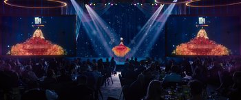 Movie still from “Bros” (2022), directed by Nicholas Stoller – A large group of people sitting at tables in front of a stage; Extreme Wide shot, Over the shoulder angle