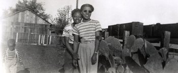 Movie still from “Bros” (2022), directed by Nicholas Stoller – A couple of people standing next to each other in a field; Medium shot, High angle