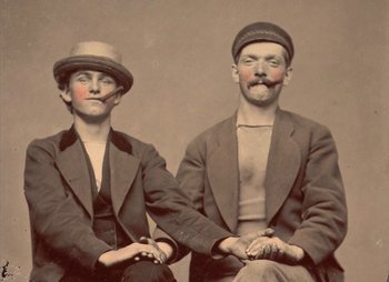 Movie still from “Bros” (2022), directed by Nicholas Stoller – A couple of men sitting next to each other; Medium shot, Low angle