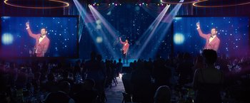 Movie still from “Bros” (2022), directed by Nicholas Stoller – A man on a stage in front of an audience; Extreme Wide shot, Over the shoulder angle