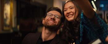 Movie still from “Bros” (2022), directed by Nicholas Stoller – A man and a woman smiling for the camera; Close Up shot, Low angle