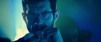 Movie still from “Bros” (2022), directed by Nicholas Stoller – A person holding a drink; Close Up shot, Over the shoulder angle