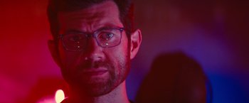 Movie still from “Bros” (2022), directed by Nicholas Stoller – A person wearing glasses; Close Up shot, Low angle