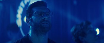 Movie still from “Bros” (2022), directed by Nicholas Stoller – A man with glasses is looking up at the sky; Close Up shot, Low angle