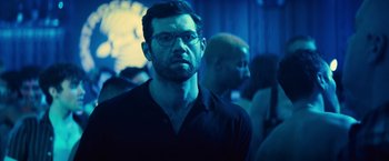 Movie still from “Bros” (2022), directed by Nicholas Stoller – A person wearing glasses and a black shirt; Close Up shot, Over the shoulder angle