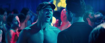 Movie still from “Bros” (2022), directed by Nicholas Stoller – A man in a hat is talking to another man in a suit; Close Up shot, Over the shoulder angle