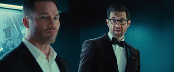 Movie still from “Bros” (2022), directed by Nicholas Stoller – A man in a suit standing next to another man in a suit; Close Up shot, Over the shoulder angle