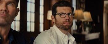 Movie still from “Bros” (2022), directed by Nicholas Stoller – A person wearing glasses and a white shirt; Close Up shot, Over the shoulder angle