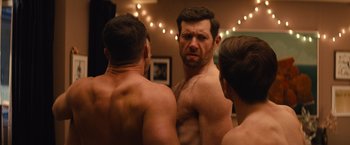 Movie still from “Bros” (2022), directed by Nicholas Stoller – A group of shirtless men looking at each other in a mirror; Medium shot, Over the shoulder angle