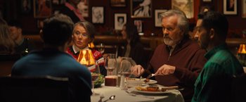 Movie still from “Bros” (2022), directed by Nicholas Stoller – A man and a woman sitting at a dinner table; Medium shot, Over the shoulder angle