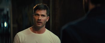 Movie still from “Bros” (2022), directed by Nicholas Stoller – A person wearing a white t - shirt; Close Up shot, Over the shoulder angle