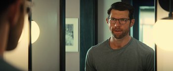 Movie still from “Bros” (2022), directed by Nicholas Stoller – A person wearing glasses in a room; Close Up shot, Over the shoulder angle