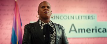 Movie still from “Bros” (2022), directed by Nicholas Stoller – A man in a black jacket and a leopard print tie; Close Up shot, Low angle