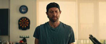 Movie still from “Bros” (2022), directed by Nicholas Stoller – A person wearing a hat; Close Up shot, Over the shoulder angle