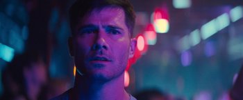 Movie still from “Bros” (2022), directed by Nicholas Stoller – A person wearing a white t - shirt; Close Up shot, Over the shoulder angle