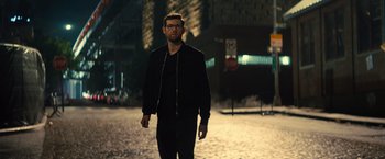Movie still from “Bros” (2022), directed by Nicholas Stoller – A man walking down a street at night; Medium shot, Low angle
