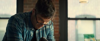 Movie still from “Bros” (2022), directed by Nicholas Stoller – A man in glasses looking down at a cell phone; Close Up shot, Over the shoulder angle