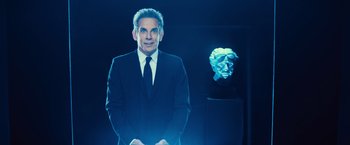 Movie still from “Bros” (2022), directed by Nicholas Stoller – A man in a suit and tie standing in front of a sculpture; Medium shot, Over the shoulder angle