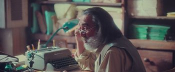 Movie still from “Burning Patience” (2022), directed by Rodrigo Sepúlveda – An older man sitting in front of an old fashioned typewriter; Close Up shot, Over the shoulder angle