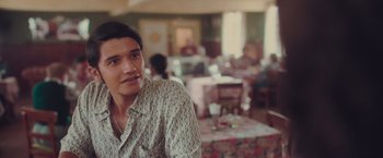 Movie still from “Burning Patience” (2022), directed by Rodrigo Sepúlveda – A man sitting at a table in a restaurant; Close Up shot, Over the shoulder angle