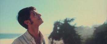 Movie still from “Burning Patience” (2022), directed by Rodrigo Sepúlveda – A man looking up at the sky with his eyes closed; Close Up shot, Low angle