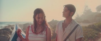 Movie still from “Burning Patience” (2022), directed by Rodrigo Sepúlveda – A man and a woman standing next to each other on top of a hill; Medium shot, Low angle