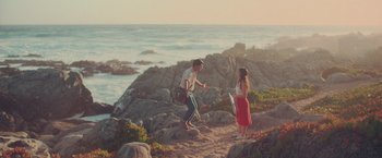 Movie still from “Burning Patience” (2022), directed by Rodrigo Sepúlveda – A man and a woman standing next to a body of water; Wide shot, High angle