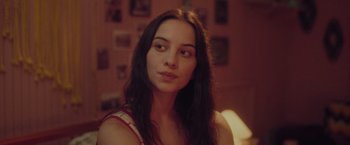 Movie still from “Burning Patience” (2022), directed by Rodrigo Sepúlveda – A beautiful young woman with long dark hair; Close Up shot, Over the shoulder angle