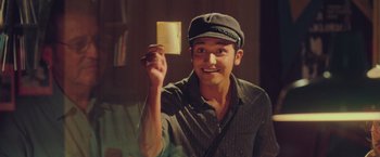 Movie still from “Burning Patience” (2022), directed by Rodrigo Sepúlveda – A man holding up a piece of paper in his hand; Close Up shot, Low angle