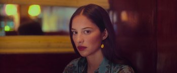 Movie still from “Burning Patience” (2022), directed by Rodrigo Sepúlveda – A beautiful woman with long dark brown hair wearing a floral shirt; Close Up shot, Low angle