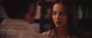 Movie still from “Burning Patience” (2022), directed by Rodrigo Sepúlveda – A person sitting in front of another person; Close Up shot, Over the shoulder angle