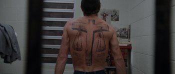 Movie still from “Cape Fear” (1991), directed by Martin Scorsese – A man with a cross tattoo on his back; Medium shot, Overhead angle