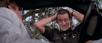Movie still from “Cape Fear” (1991), directed by Martin Scorsese – A man in a black shirt is putting his hair up; Close Up shot, Over the shoulder angle